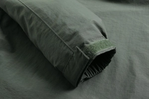 Detail of military green outdoor jacket cuff with adjustable velcro strap and elastic band