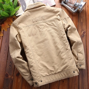 Detail of khaki canvas jacket with sherpa collar and warm fleece lining on wood background