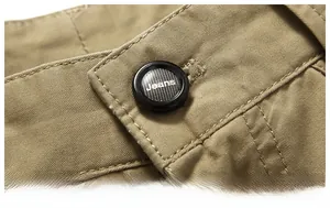 Detailed macro view of khaki cotton twill shorts featuring a premium black jeans button