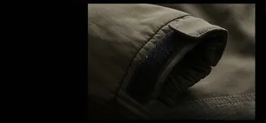 Detail of army green jacket cuff featuring durable twill fabric and adjustable velcro strap