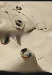 Détail de la veste en coton kaki avec coutures doublées et boutons en résine marbrée