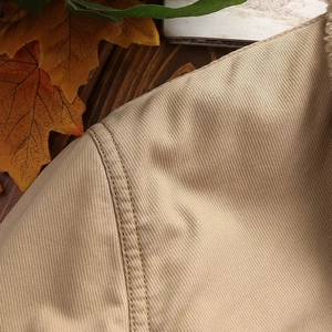 Detailed macro view of khaki twill fabric with sturdy double-stitch sewing seams