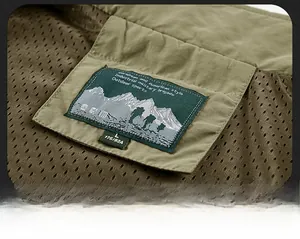 Détail macro de la doublure en maille respirante et étiquette sur un gilet de pêche vert