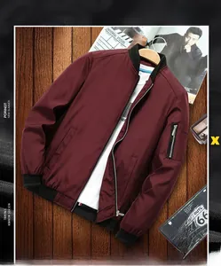 Detailed view of burgundy bomber jacket sleeve with utility pocket on wooden background