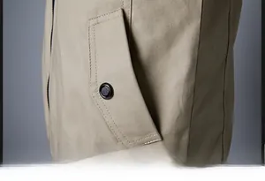 Detailed macro view of khaki cotton jacket showing slanted pocket with buttoned flap
