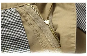 Close-up of khaki cotton shorts showing metal zipper and plaid inner lining detail