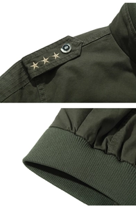 Detail of army green jacket featuring gold star shoulder epaulettes and ribbed cuffs