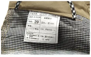 Macro detail of men's khaki shorts showing the white cotton wash label and inner lining