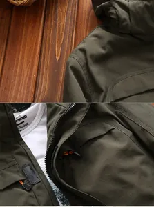 Detailed view of the army green outdoor jacket featuring orange zip pulls and Velcro cuffs