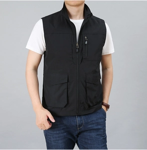 Detail of black utility vest featuring multiple functional zip and flap pockets