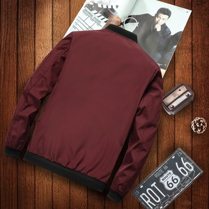 Men's wine red bomber jacket with black ribbed cuffs displayed on a vintage wood background