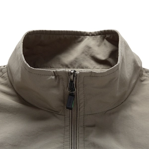 Macro view of the stand-up collar and sports zipper detail on this khaki vest