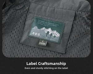 Detail view of charcoal gray vest collar with green woven label and breathable mesh lining