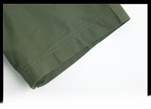 Dettaglio del polsino della camicia in cotone verde militare con robuste doppie cuciture