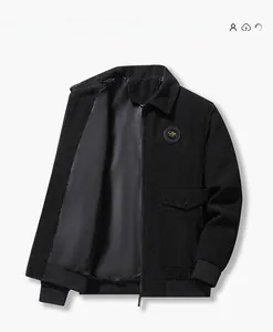 Détail d'une veste en velours côtelé noir avec fermeture éclair, col et écusson