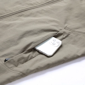 Macro detail of the outdoor vest side zipper pocket showing a smartphone storage capacity