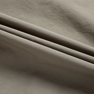 Detailed macro view of dark khaki functional vest fabric showing high-density woven texture