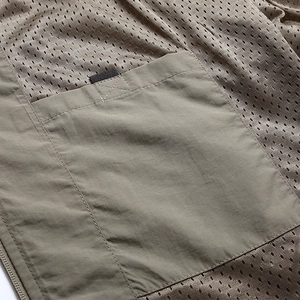 Detail of outdoor vest featuring breathable honeycomb mesh lining and reinforced stitching