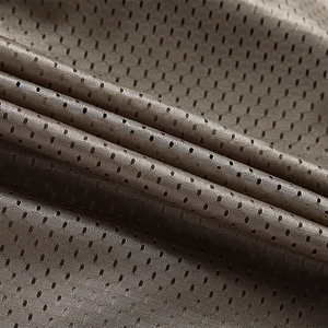 Detailed macro view of brown breathable mesh fabric used in outdoor utility vests