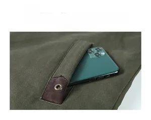 Detail of army green jacket featuring reinforced leather pocket with bronze rivets and phone