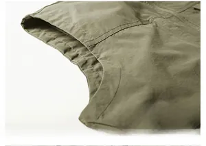 Detail shot of precise stitching on the sleeve armhole of a green outdoor vest