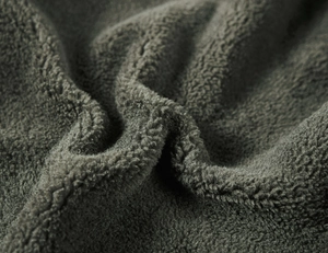 Macro shot of dark grey polar fleece fabric showing thick warmth and soft texture
