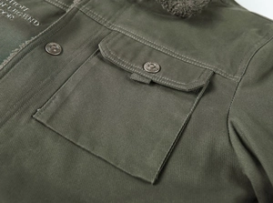 Detail of olive green deck jacket showing fleece collar and embossed metal buttons