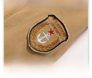 Detail of khaki twill cotton winter jacket with embroidered anchor shield badge and fur collar