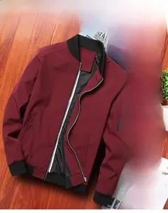 Detail view of burgundy bomber jacket showing black ribbed cuffs and utility sleeve pocket