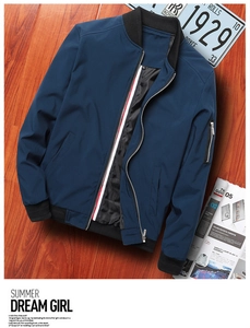 Detail of dark blue bomber jacket showing ribbed cuffs and tricolor striped zipper trim
