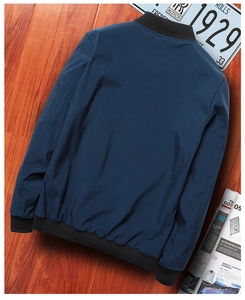 Back view of navy blue bomber jacket featuring ribbed collar and vintage prop accents