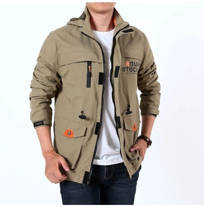 Detail of khaki outdoor jacket showing orange zippers and utility pockets on a model