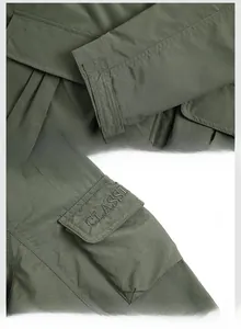 Detail view of army green jacket with adjustable velcro cuffs and classic embroidery pocket