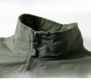 Close-up of stand-up collar with metallic zipper and SPORTS engraving on the olive vest