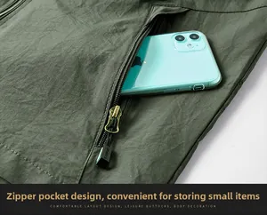 Detail view of the deep green outdoor vest featuring a zipper pocket and durable fabric