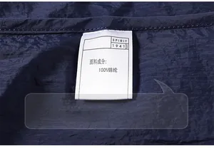 Macro detail of washing label showing 100% nylon fabric on blue summer sun protection jacket