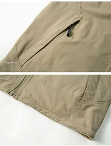 Detail of khaki outdoor vest showing zipper pocket with SPORTS engraving and tech fabric texture