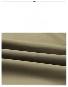 Close-up of olive green tactical jacket fabric texture with premium stitching details