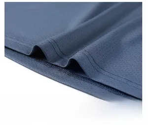 Detailed macro view of breathable mesh fabric texture and durable hem stitching on shirt