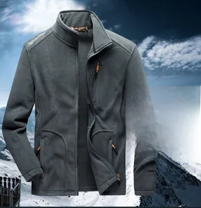 Detail of grey fleece jacket featuring high collar and zippered pockets on mountain background