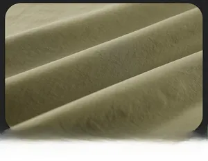Detail van de zachte olijfgroene geborstelde stof voor een zwaar buitenvisvest voor heren
