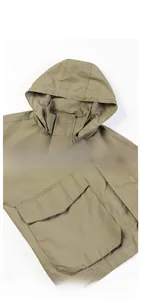 Detail view of military green utility jacket showing hood, mesh lining and flap pockets