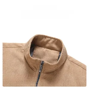Detail of khaki corduroy jacket with stand collar, metal zipper, and striped lining