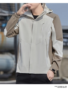 Detail of color-block windbreaker jacket featuring a hooded neckline and zip pocket