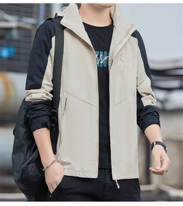 Close-up of khaki and black color-block windbreaker jacket with sport logo detail