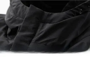 Détail du col coupe-vent à cordon de serrage sur une veste d'extérieur noire technique