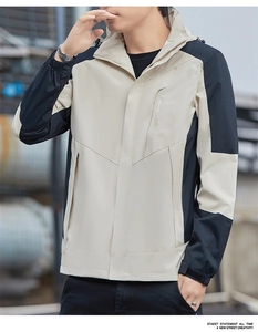 Detail of outdoor jacket showing khaki and black contrast panels and sleeve cuff strap