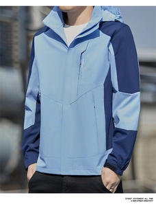 Detail of blue outdoor windbreaker showing hooded collar and adjustable velcro cuffs