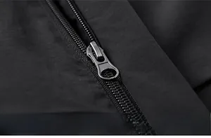Détail macro de la fermeture éclair métallique et du tissu noir texturé de cette veste homme