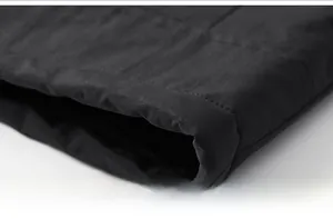 Vue macro de la couture de l'ourlet sur une veste coupe-vent noire avec finitions précises